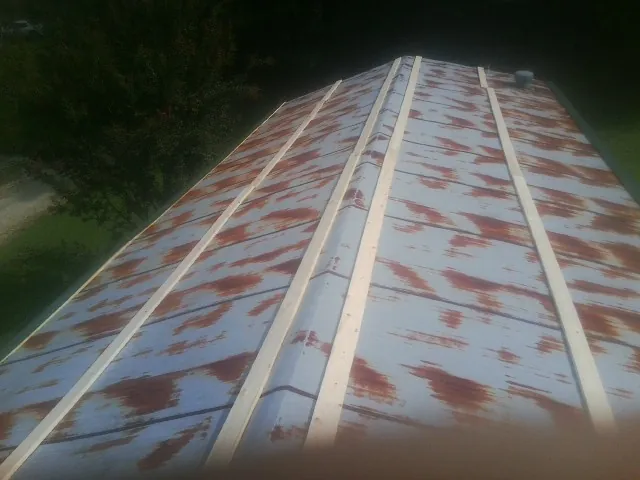 Rusted metal roof panels with new wood purlins before replacement — Storm Damage Roof Repair in Goshen by Roofing Brothers