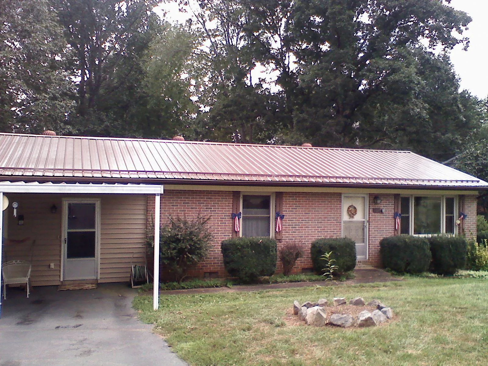 Bronze metal roof and carport on a brick ranch home — Roof Repair work by our crew in Goshen